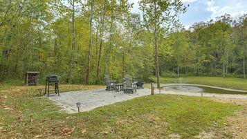 A patio area with outdoor furniture, a grill, and a pond.