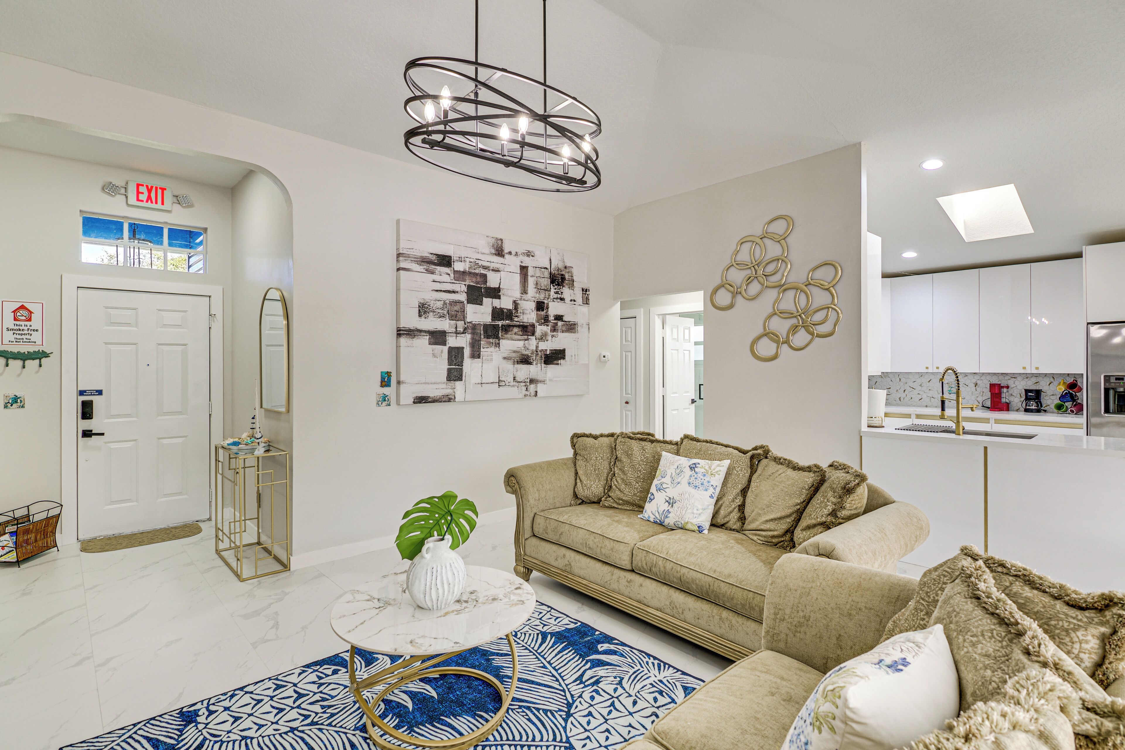 A modern living room with a sofa, a coffee table, and a chandelier.
