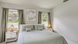 A bedroom with a bed, nightstands, a lamp, and curtains. - Fenced Yard, Game Room: Family Home in Sebastian! (Sebastian)