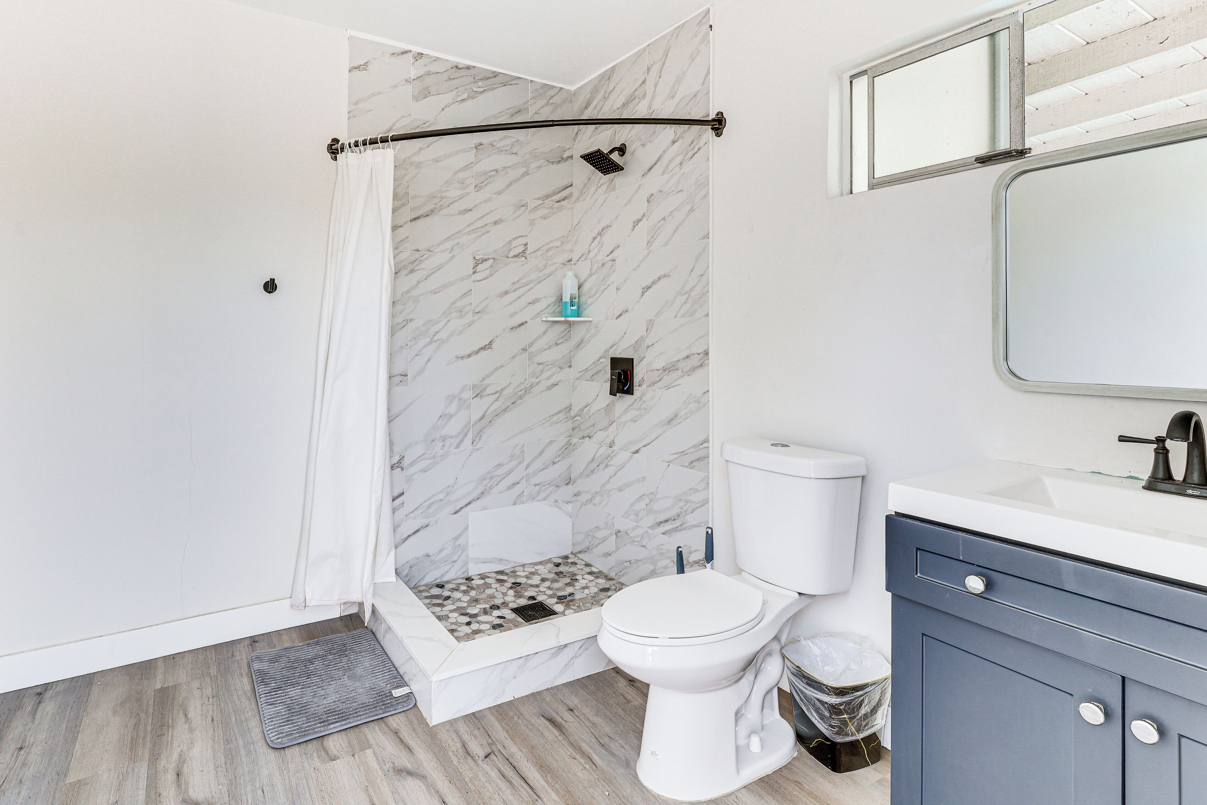 A bathroom with a shower, toilet, and vanity.