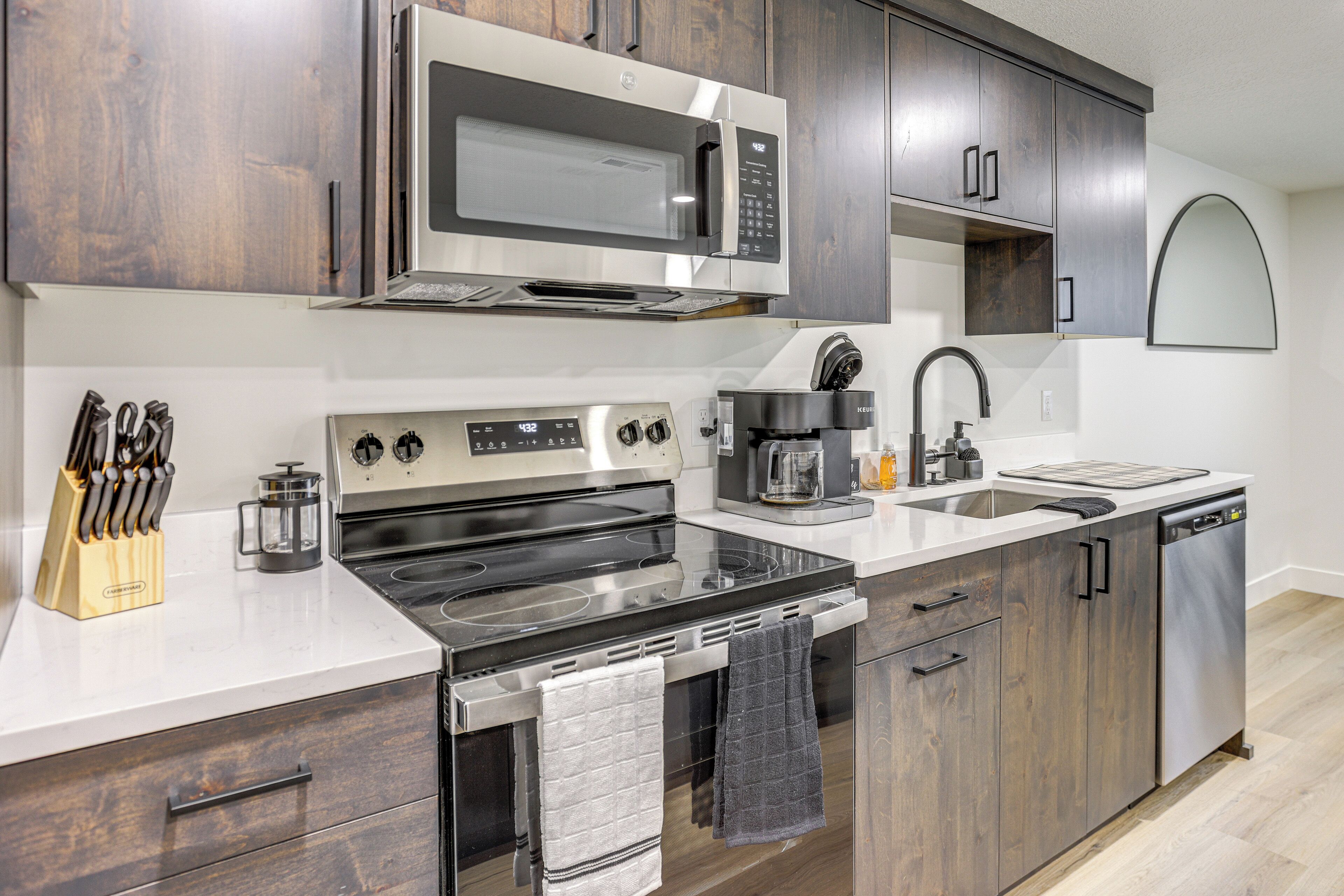 A modern kitchen with a built-in microwave, stove, and dishwasher.