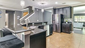 A modern kitchen with granite countertops, stainless steel appliances, and a central island with seating.