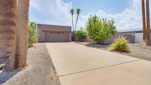 A residential area with a concrete driveway, palm trees, and a garage. - Mtn-view Getaway w/ Pool: 4 Mi to Dtwn Palm Desert (Palm Desert)