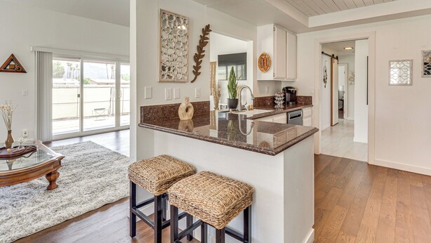 A spacious kitchen with a central island, wooden flooring, and a view to the outside. - Mtn-view Getaway w/ Pool: 4 Mi to Dtwn Palm Desert (Palm Desert)