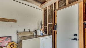 A laundry area with a washing machine, a sink, and a wooden door. - Mtn-view Getaway w/ Pool: 4 Mi to Dtwn Palm Desert (Palm Desert)