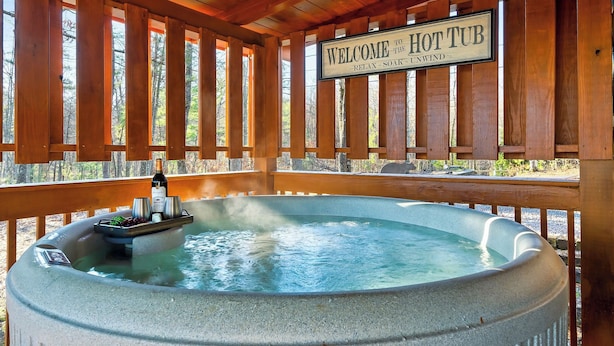 Ein Whirlpool mit einem Schild, das 'Willkommen im Whirlpool' sagt, und einer Weinflasche auf einem Tablett.