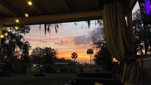 An outdoor seating area with a view of a sunset.