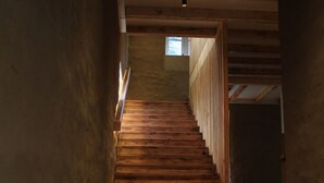 A wooden staircase leading to an upper floor, with a small window at the top.