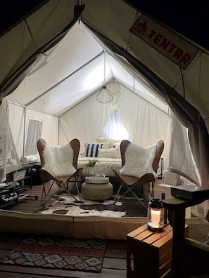 A tent with a bed, two chairs, a small table with a candle, and a welcome mat. - Serene Glamping Tent Incredible to Relax and Disconnect in Delta, Colorado (Delta)