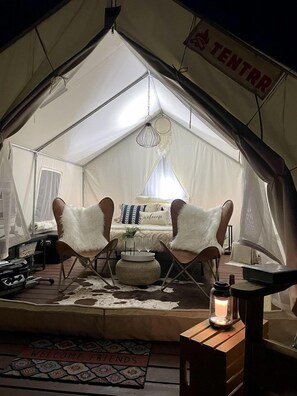 A tent with a bed, two chairs, a small table with a candle, and a welcome mat. - Serene Glamping Tent Incredible to Relax and Disconnect in Delta, Colorado (Delta)