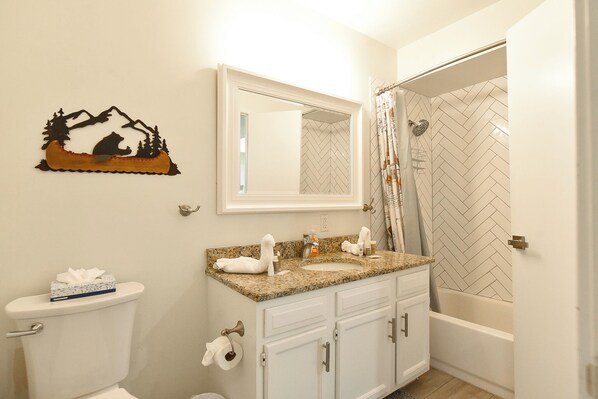 A bathroom with a toilet, sink, and shower.