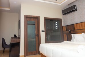 Una habitación de hotel con cama, escritorio y armario.