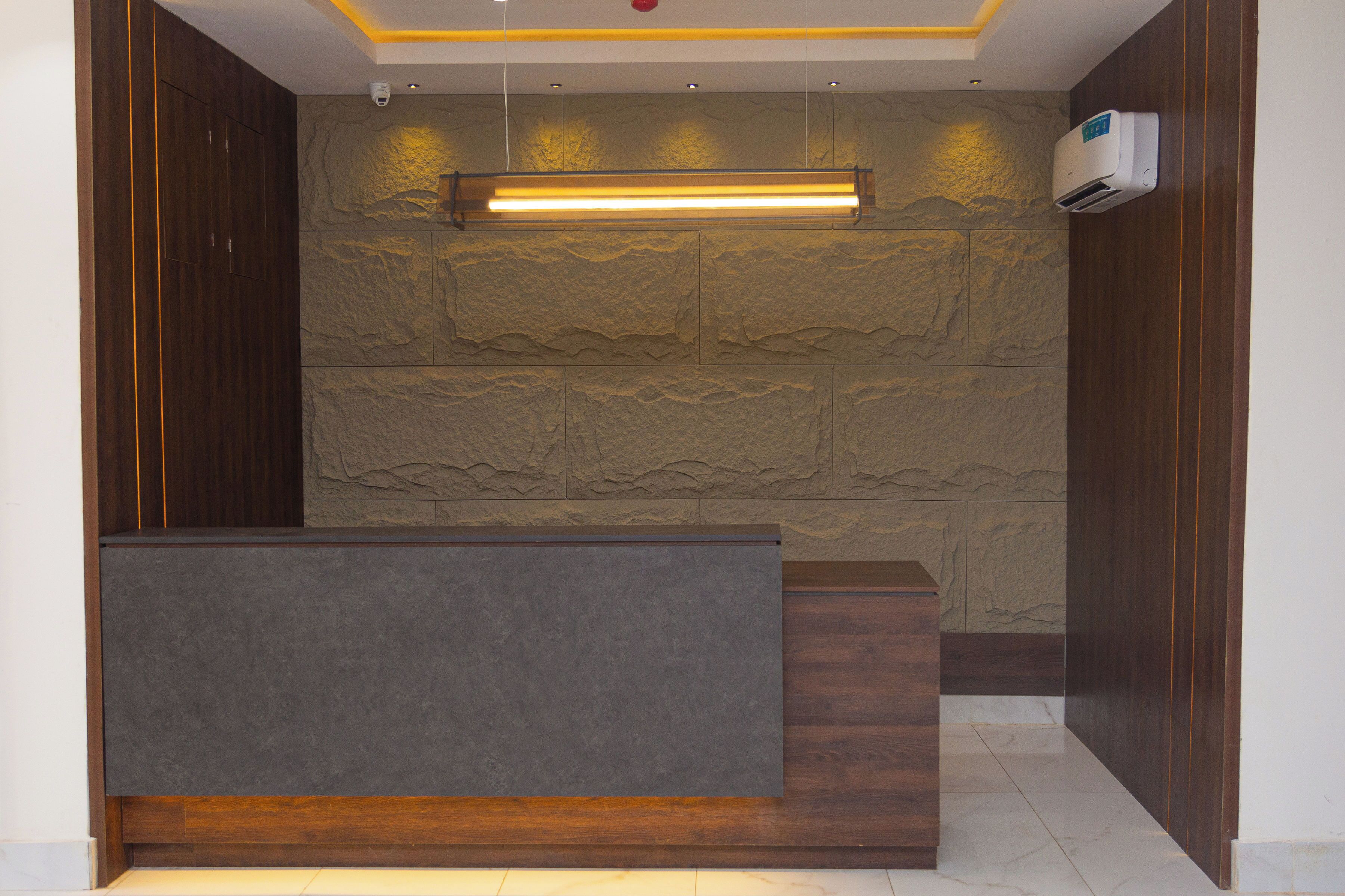 A reception area with a stone wall, wooden paneling, and a modern reception desk.