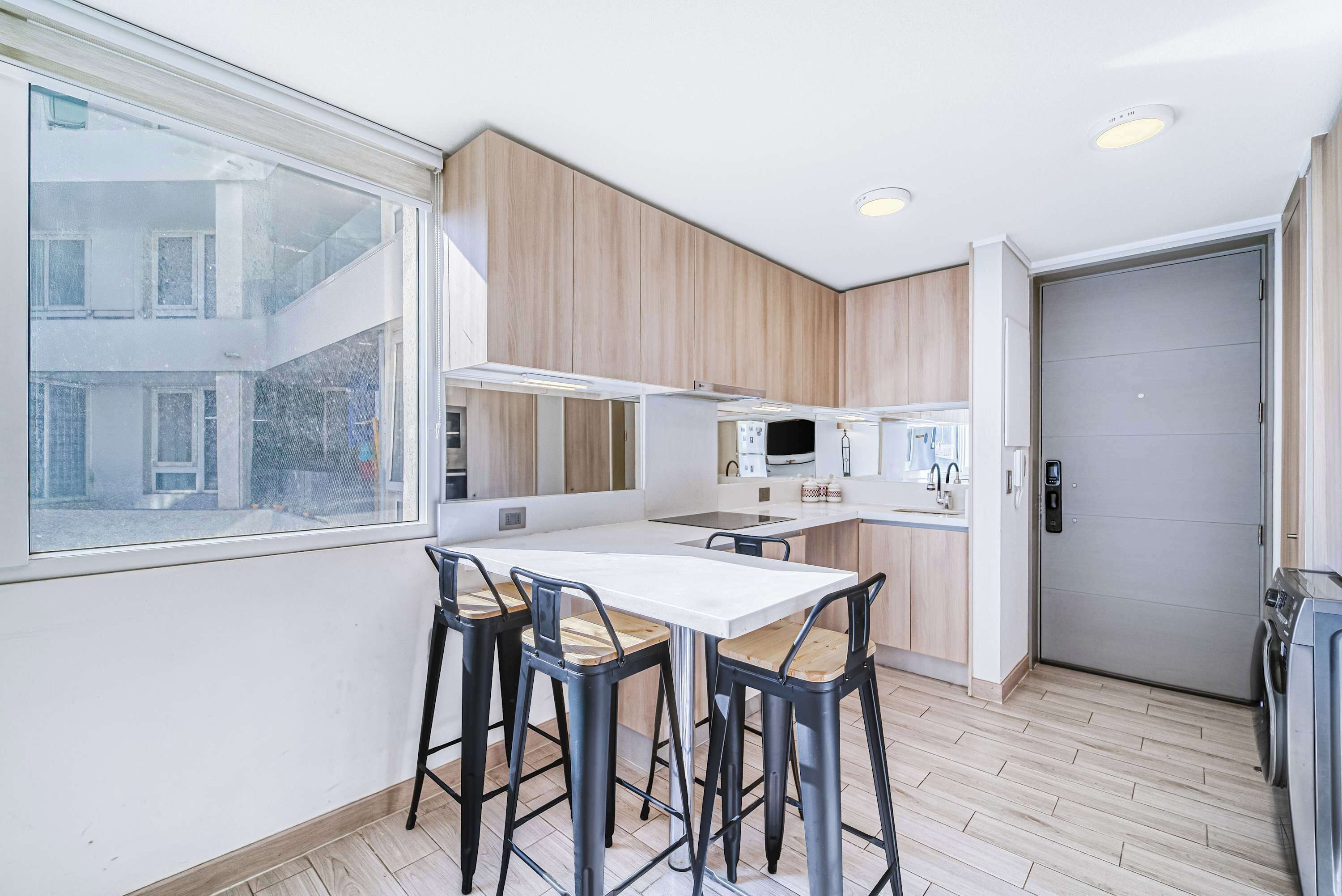 Una cucina moderna con zona pranzo, mobili in legno e un'ampia finestra.