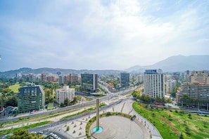 A cityscape with modern buildings, a central roundabout, and a prominent vertical structure.