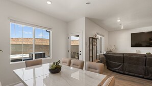 A modern kitchen with a large island, white cabinetry, and a view of the desert landscape. - Sand Hollow Serenity: Private Hot Tub (Washington)