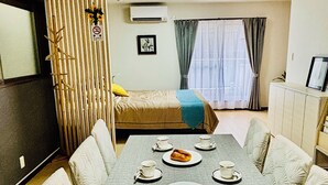 A modern hotel room with a dining area, a bed, and a kitchenette. - Nagomi no Yado Umeda 1 station 3 min. walk from station 1 building 4 rooms for private use Kyoto-Kobe direct access (大阪市淀川区十三本町2丁目)