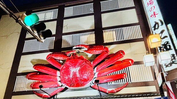 A building with a large crab decoration above the entrance, a sign with Japanese characters, and bicycles parked outside. - Nagomi no Yado Umeda 1 station 3 min. walk from station 1 building 4 rooms for private use Kyoto-Kobe direct access (大阪市淀川区十三本町2丁目)