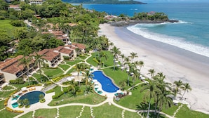 A resort with a pool, beach, and ocean view.