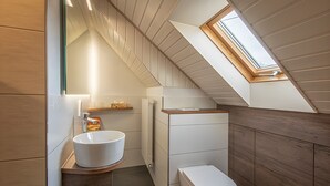 A modern bathroom with a skylight, a white sink, and a toilet. - Studio 'Kornblümchen' with private terrace, shared garden and Wi-Fi (Oberharmersbach)