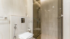 A modern bathroom with a glass-enclosed shower, a toilet, and a sink. - Furnished Studio with Burj Khalifa View, Near Dubai Water Canal (Dubai)