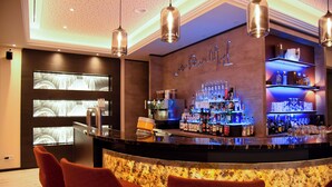 Una zona de bar con un mostrador curvo, diversas opciones de asiento y un ambiente luminoso.