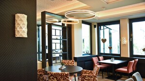 Un comedor moderno con una mesa redonda, sillas estampadas e iluminación colgante.