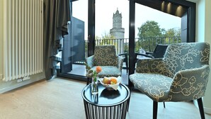 Una sala de estar moderna con vistas a un castillo a través de grandes ventanales.