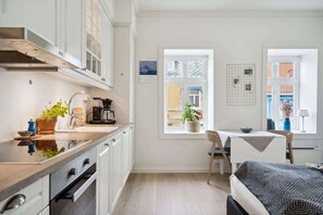 Een koelkast, een oven, kookgerei, borden en bestek