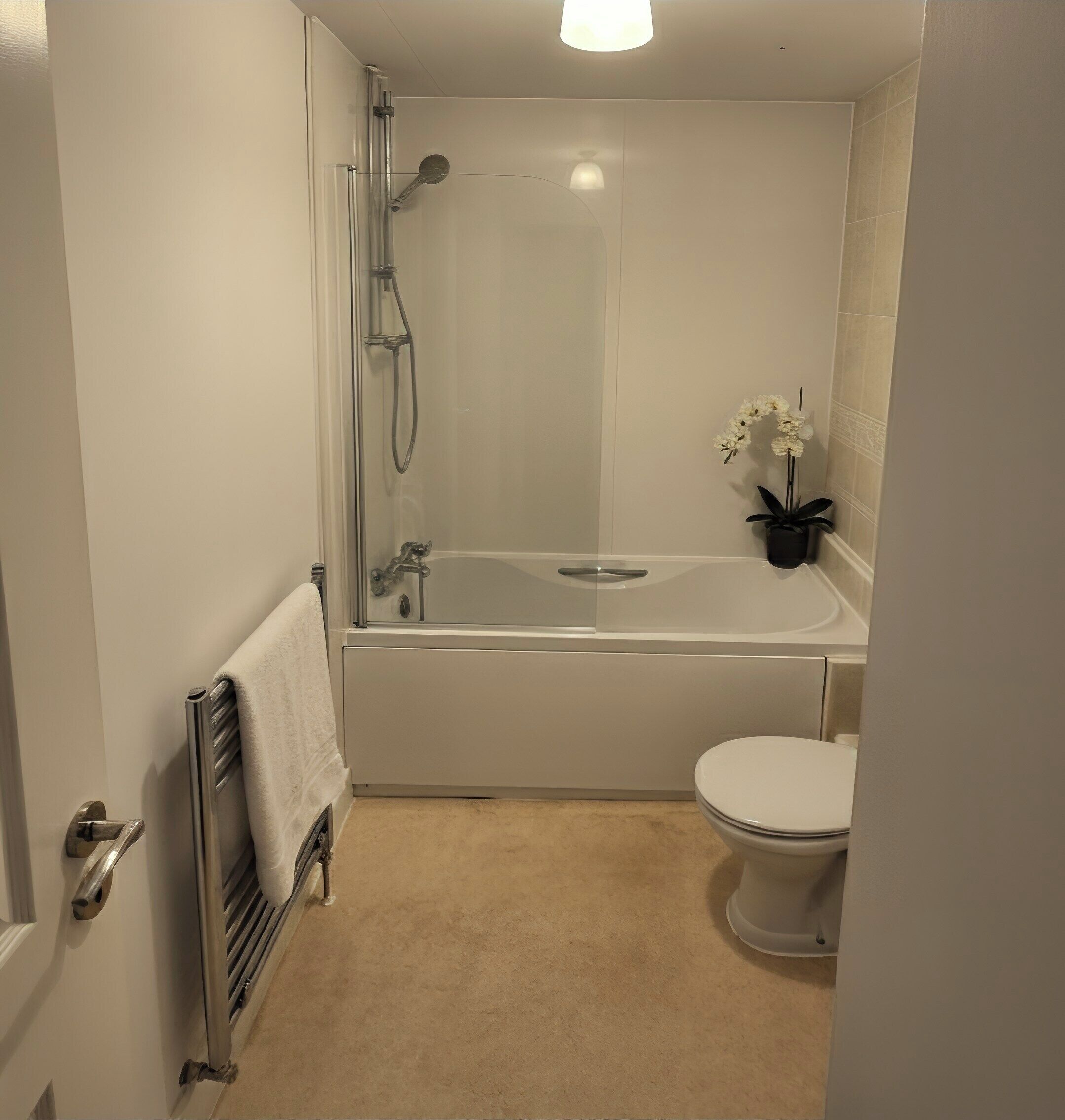 Ein Badezimmer mit Dusche, Badewanne, Toilette und einer Zimmerpflanze.