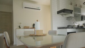 Una cocina moderna con armarios blancos, horno empotrado y pileta de acero inoxidable.