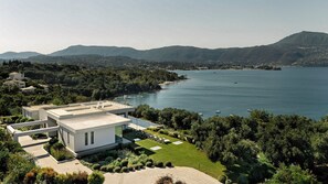 A modern house with a flat roof, a swimming pool, and a view of a lake and mountains. - Iola - Five Bedroom Villa, Sleeps 10 (Limni)