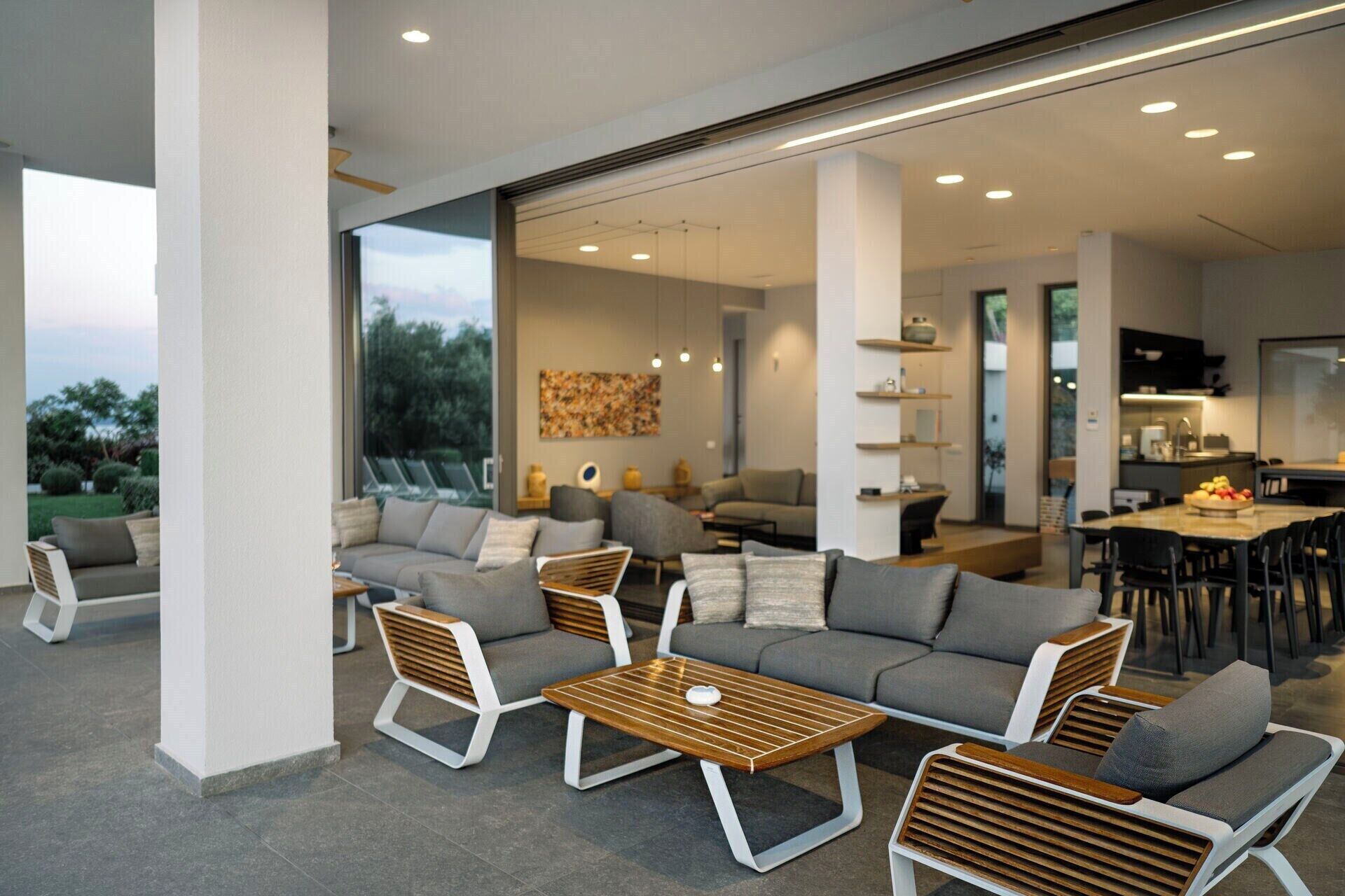 Een moderne woonkamer met een bank, stoelen en een salontafel.