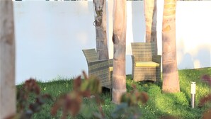 Outdoor wicker furniture with cushions, a white wall, and a grassy area with plants. - Apartment 'Piccolo' with Shared Garden and Air Conditioning (Porto Cesareo)