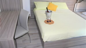 A bed with a yellow pillow, a bedside table, and a chair. - Apartment 'Piccolo' with Shared Garden and Air Conditioning (Porto Cesareo)