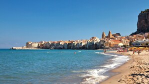 Un pueblo costero con edificios históricos, una playa y un acantilado.