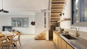 A modern kitchen with wooden cabinetry, a built-in stove, and a large window. - Eolia - Three Bedroom Villa, Sleeps 6 (Nikiana)
