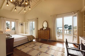 Ein Schlafzimmer mit Bett, Schminktisch und Blick ins Freie.