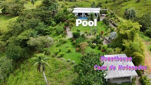 Une maison d’hôtes avec une piscine, entourée d’une végétation luxuriante.