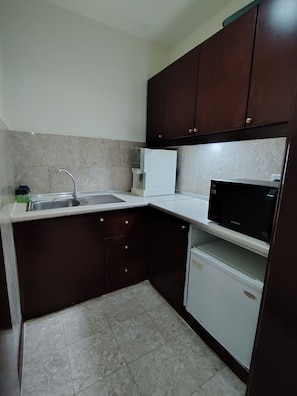 SuĂte conforto, vista para a cidade | Cozinha privada | Frigobar, micro-ondas, lava-louças, mesas de jantar