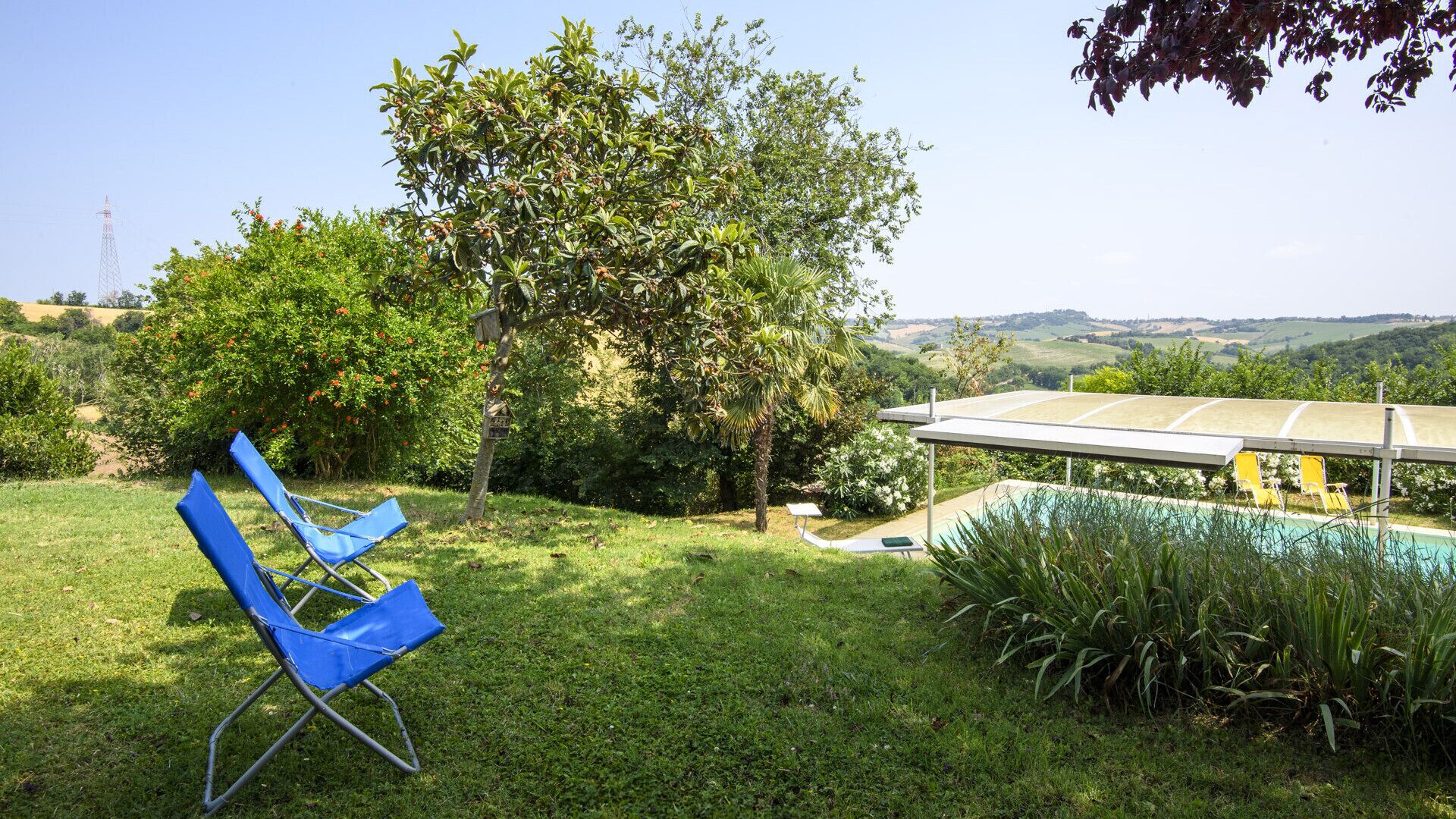 Ein Garten mit Pool, Hängesessel und Blick ins Grüne.