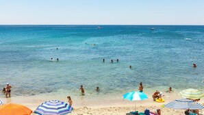 A beach with clear blue water, people swimming and sunbathing, and colorful umbrellas. - Blu Melia - Seven Bedroom Villa, Sleeps 14 (Contrada Guardiola)