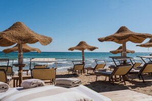 A beachside hotel with thatched umbrellas, sun loungers, and wooden tables. - OttoConi - Three Bedroom Villa, Sleeps 6 (Carpari)