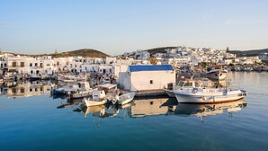 A harbor with boats docked, a small white building, and white buildings in the background. - Villa Espera - Five Bedroom Villa, Sleeps 10 (Santa Maria)