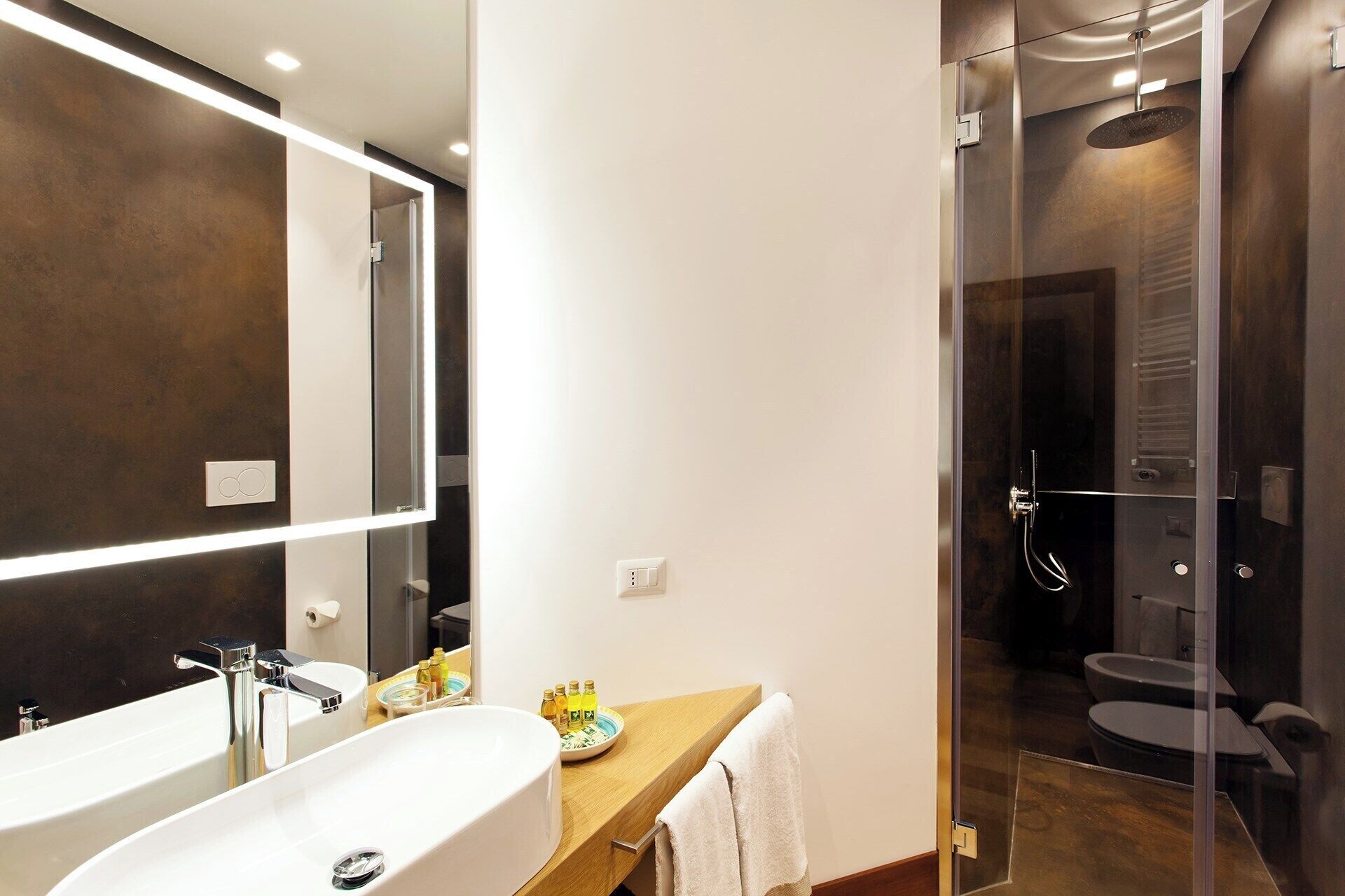 Een moderne badkamer met een grote spiegel, een wastafel en een douche.