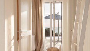 A hallway with a view to a balcony, a door, and a ladder. - Luna Rossa - Four Bedroom Villa, Sleeps 8 (Castrignano del capo)