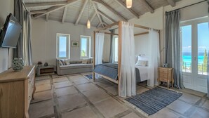 A bedroom with a wooden ceiling, a bed with a canopy, a sofa, a TV, and a view of the sea. - Madreterra - Six Bedroom Villa, Sleeps 12 (Lefkada)