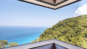 A room with a view of the sea and a forested hillside. - Noiya - Eight Bedroom Villa, Sleeps 16 (Ponti Agiou Petrou)
