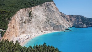 A coastal beach with a steep cliff, clear turquoise waters, and a sandy shore. - Noiya - Eight Bedroom Villa, Sleeps 16 (Ponti Agiou Petrou)