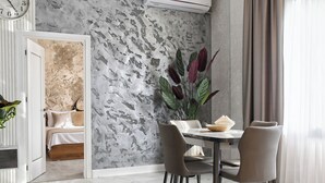 Un comedor moderno con suelo de mármol, una mesa con sillas y una planta decorativa.